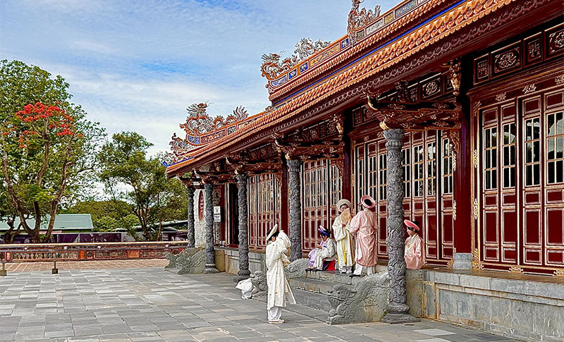 Vietnamese women in traditional áo dài at Huế’s Imperial Citadel – showing how to avoid overtourism in Asia with authentic experiences